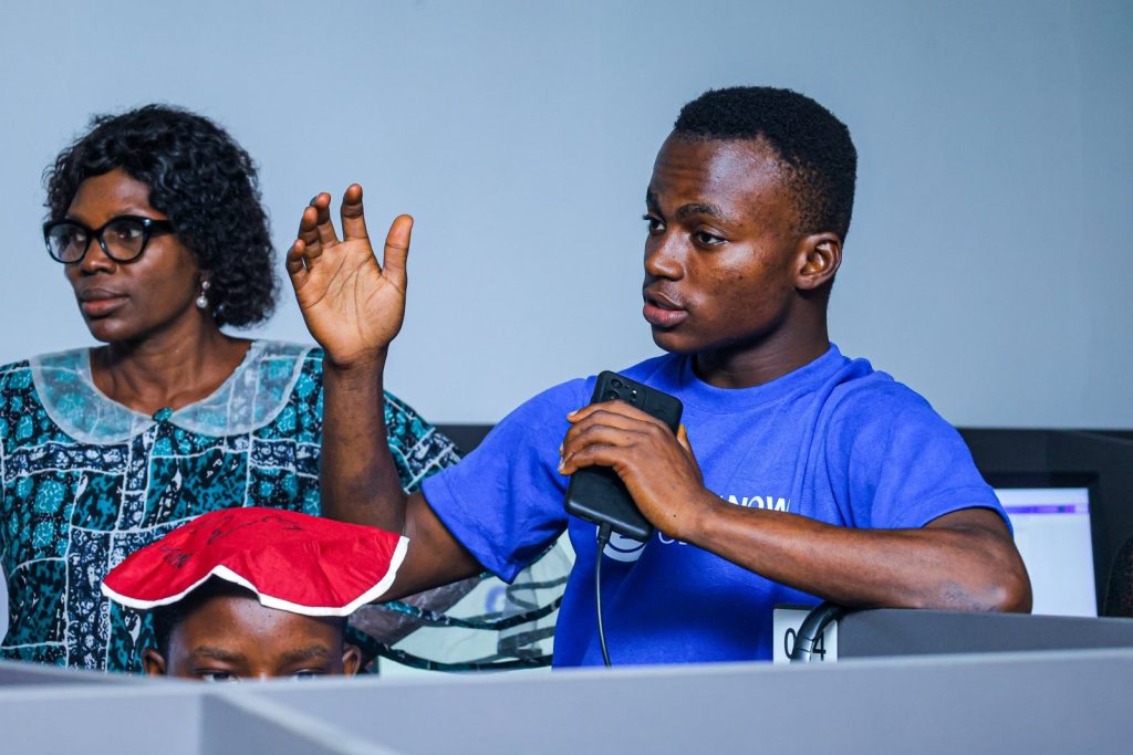David Onilude coaching alongside a teacher in a computer lab